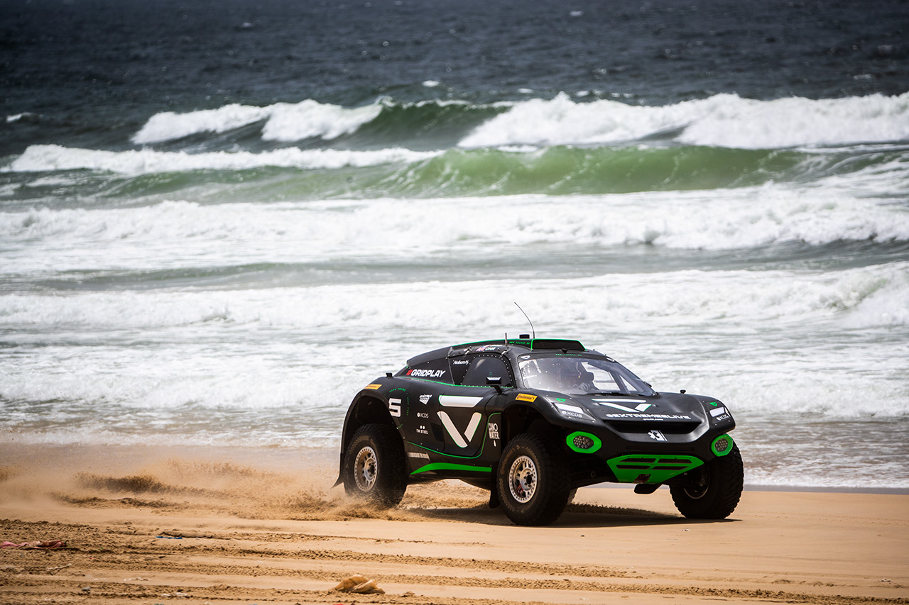 Un coche de carreras Extreme E circulando por la playa en Senegal