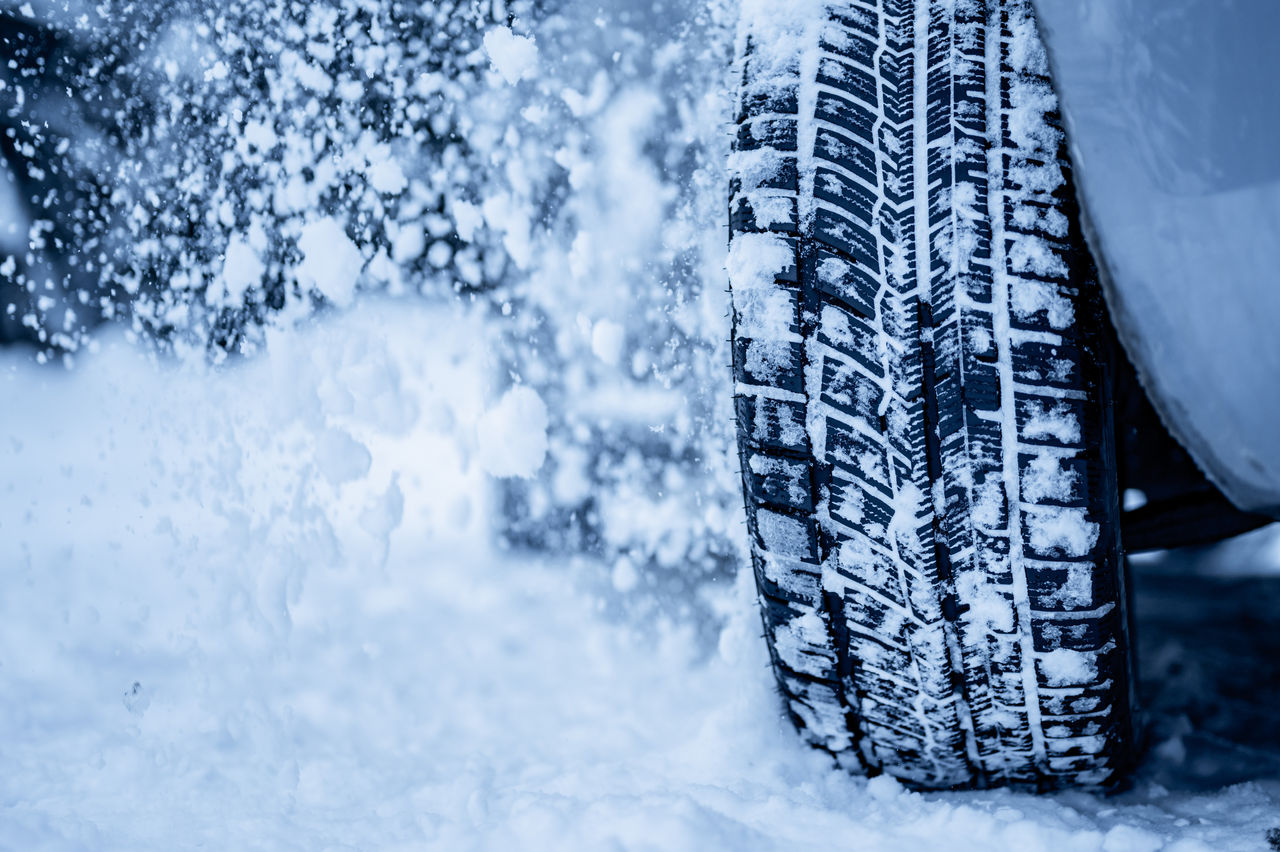 Winter tire. Detail of car tires in winter on the road covered with snow.
