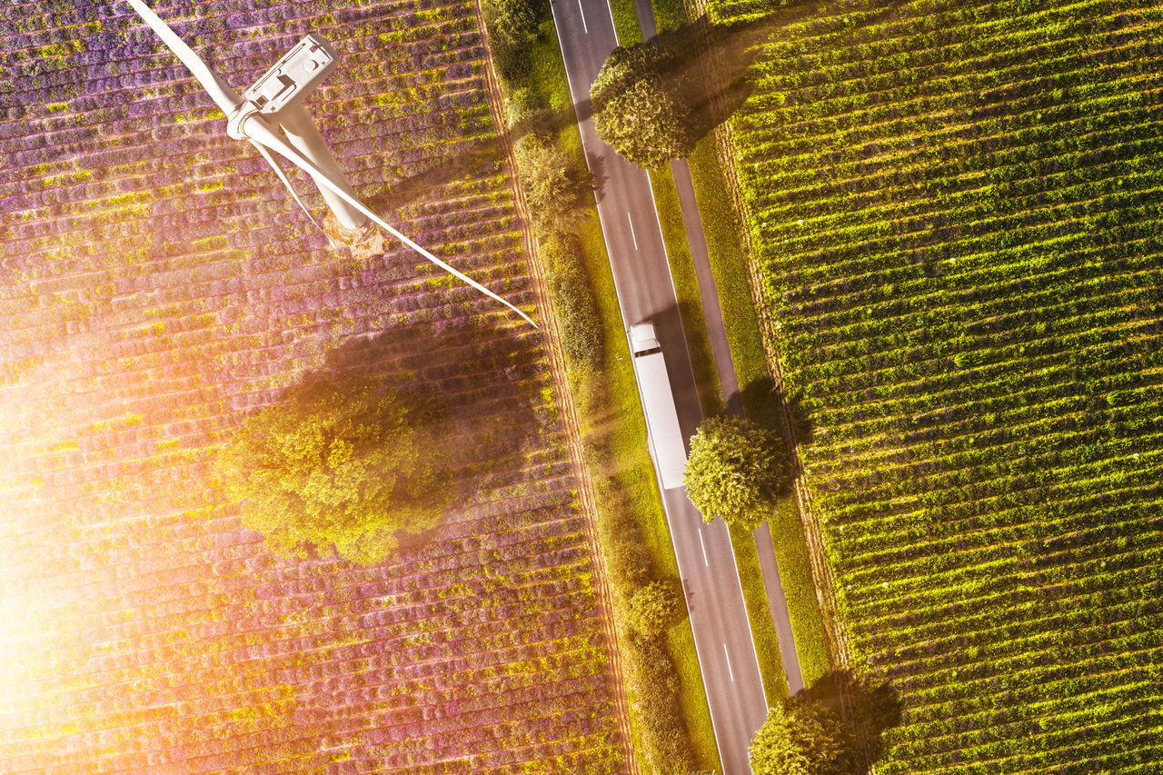 Vista aérea de un camión en una carretera comarcal con un molino de viento eléctrico